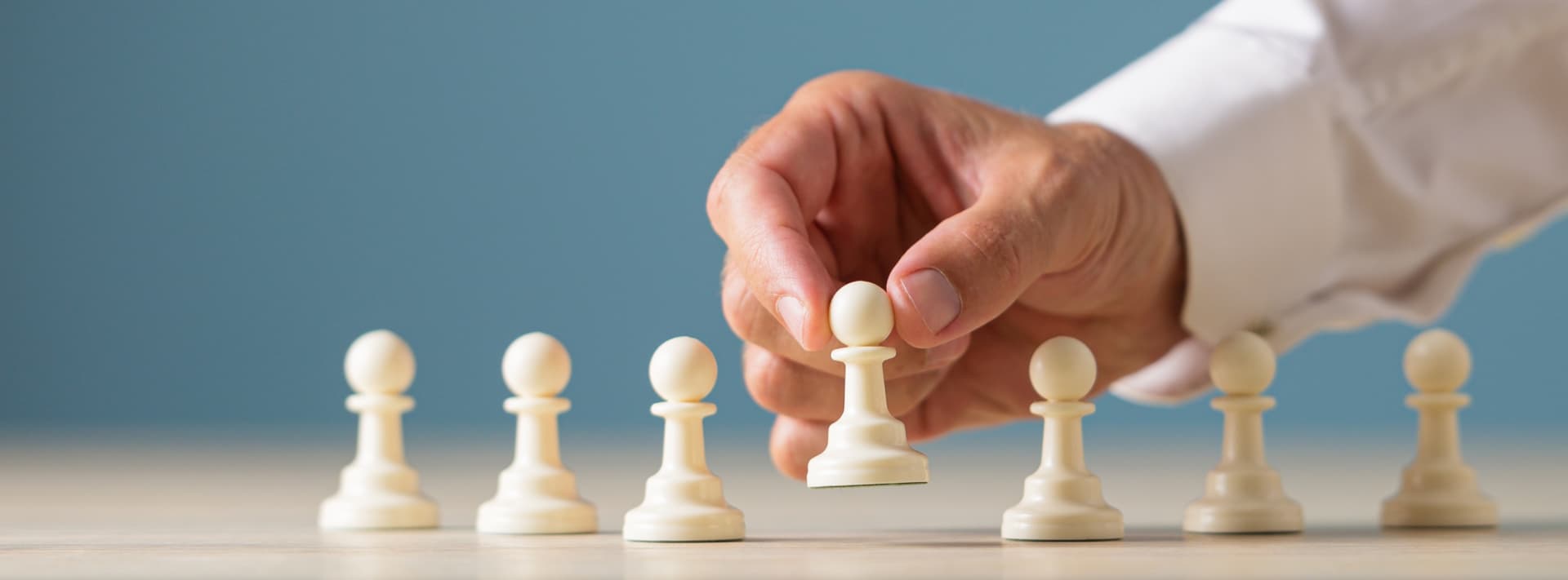 Chess pawns being placed in a line