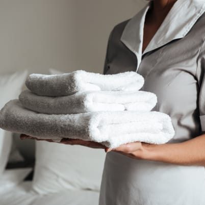 Maid holding folded towels